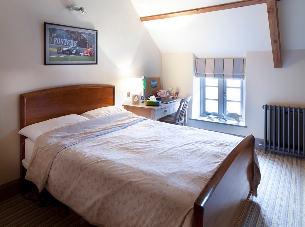 This is an example of a transitional loft-style bedroom in Gloucestershire with white walls and medium hardwood floors.
