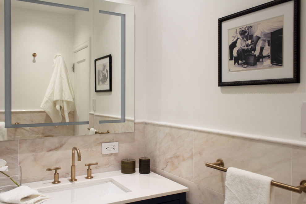 Cette image montre une petite douche en alcôve principale traditionnelle avec un placard à porte shaker, des portes de placard bleues, une baignoire encastrée, WC à poser, un carrelage beige, du carrelage en marbre, un mur beige, un sol en marbre, un lavabo encastré, un plan de toilette en quartz modifié, un sol beige, une cabine de douche à porte battante, un plan de toilette blanc, une niche, meuble simple vasque et meuble-lavabo sur pied.