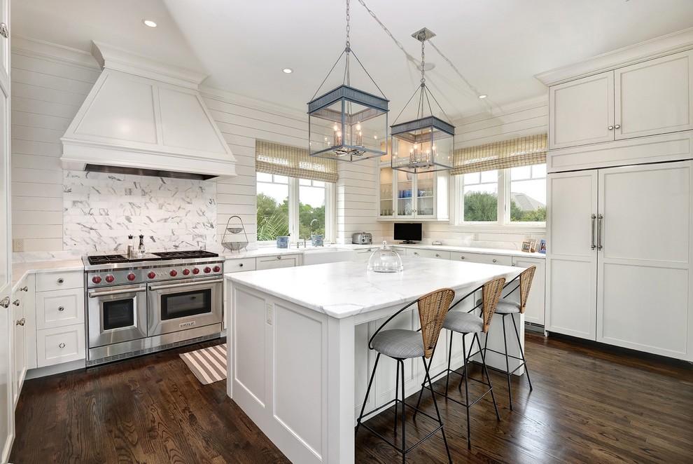 Inspiration for a large beach style u-shaped eat-in kitchen in Charleston with stainless steel appliances, with island, a farmhouse sink, shaker cabinets, white cabinets, marble benchtops and dark hardwood floors.