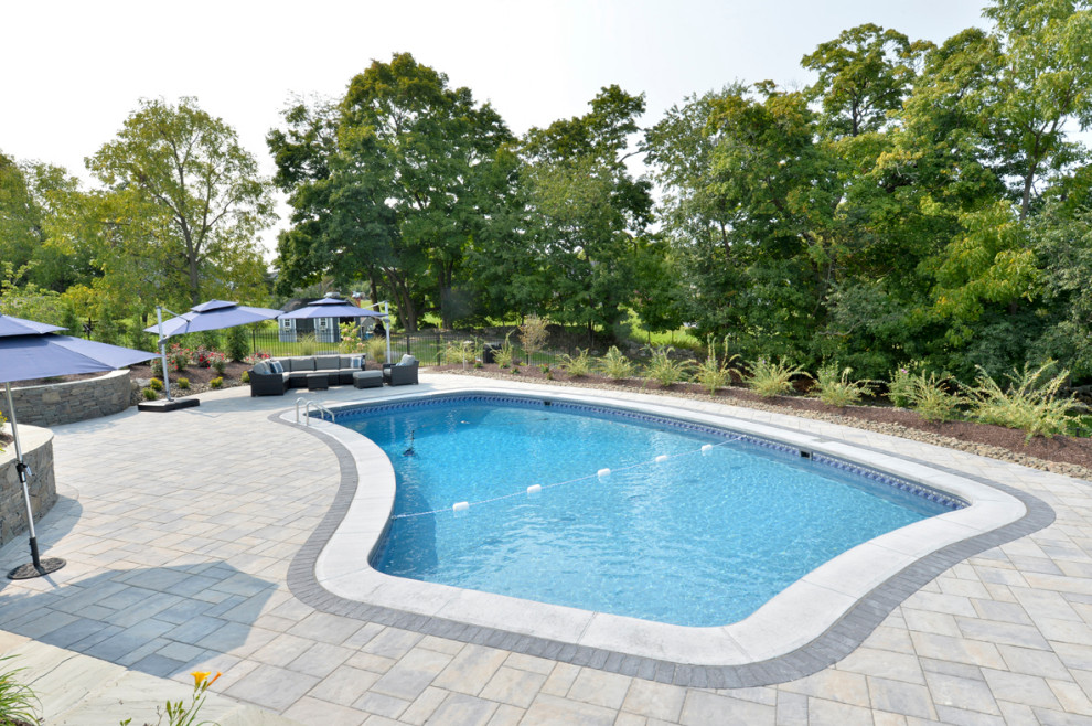 Пример оригинального дизайна: большой бассейн на заднем дворе в стиле кантри