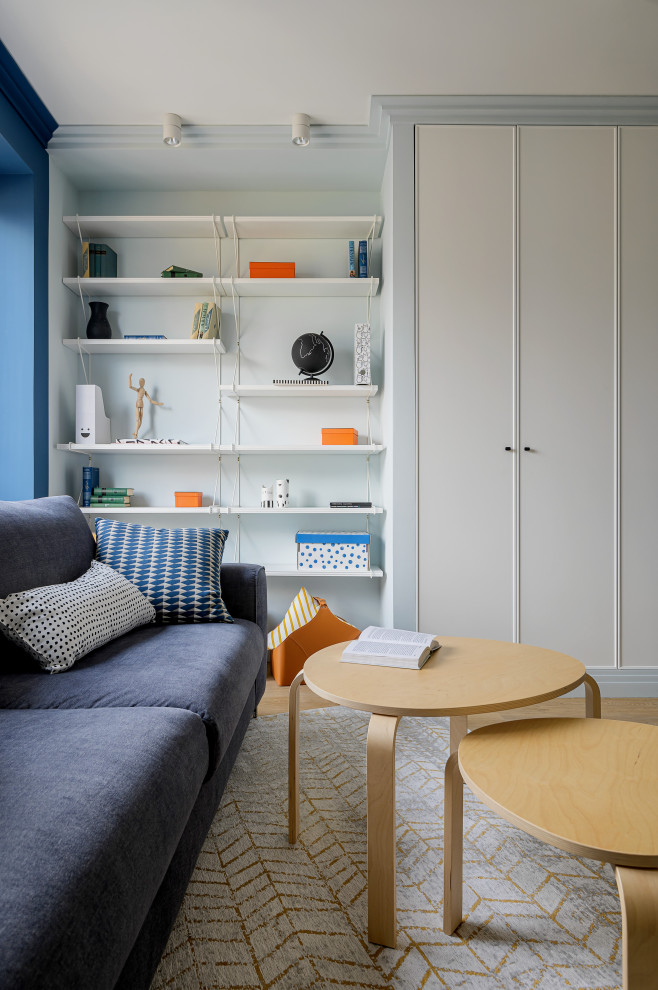 Ispirazione per un soggiorno stile marinaro con libreria, pavimento in vinile, pareti blu, TV a parete e pavimento beige