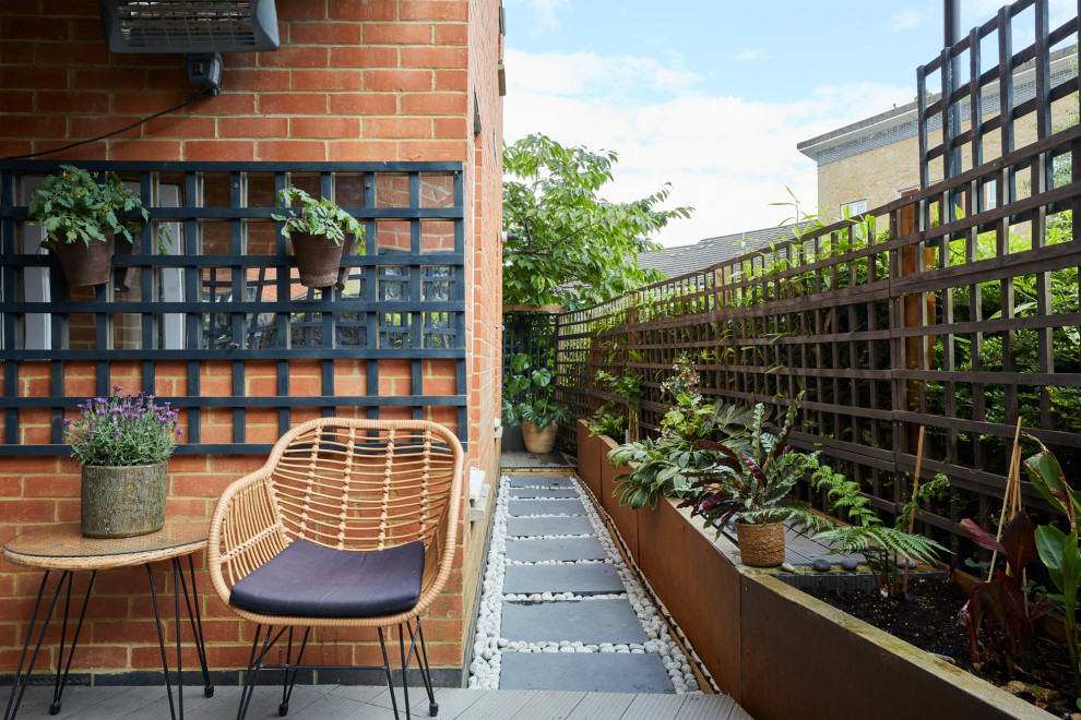 Réalisation d'un petit jardin latéral design au printemps avec une exposition partiellement ombragée, une terrasse en bois et une clôture en bois.