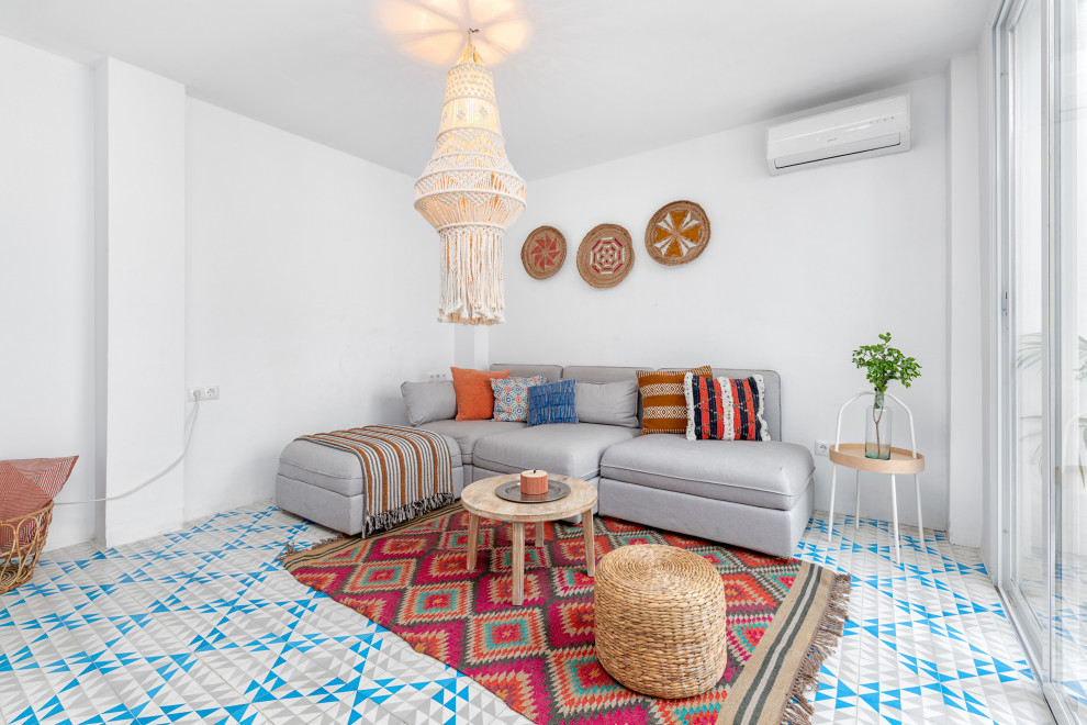 Design ideas for a mediterranean living room with white walls and multi-coloured floor.