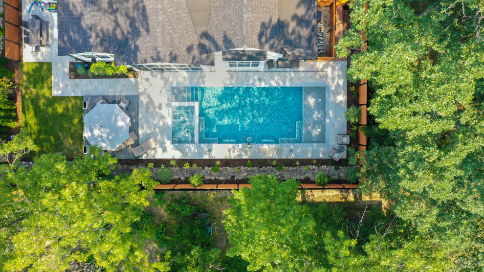 На фото: спортивный, прямоугольный бассейн среднего размера на заднем дворе в классическом стиле с перегородкой для приватности и покрытием из каменной брусчатки