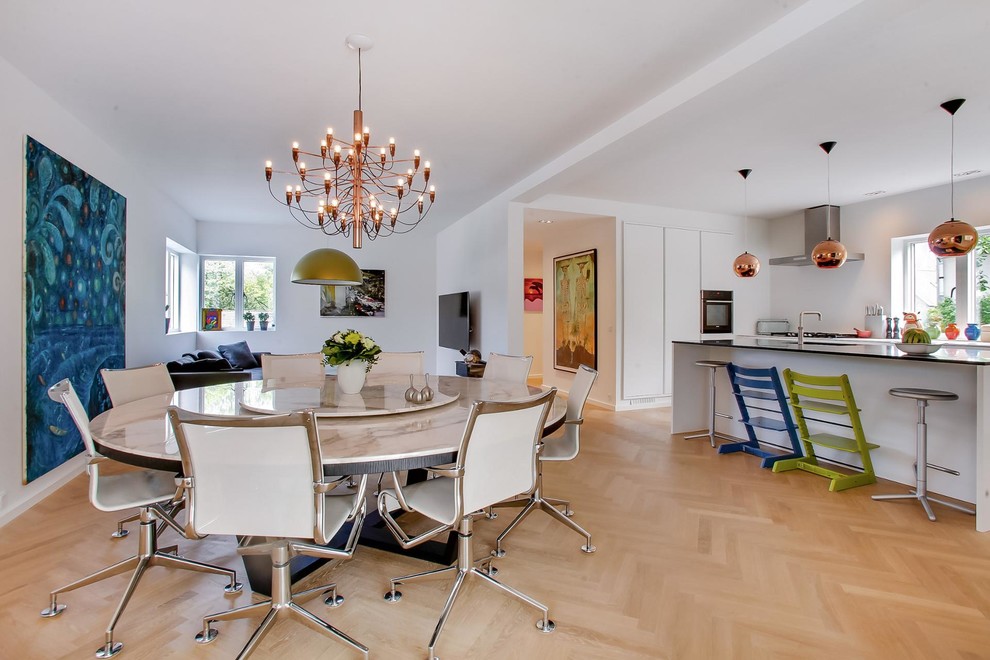 Large contemporary open plan dining in Copenhagen with white walls, light hardwood floors and no fireplace.