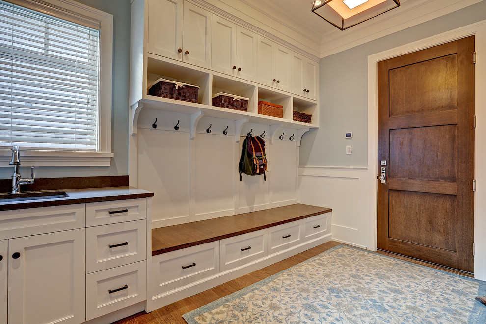 Inspiration for a mid-sized transitional mudroom in Calgary with blue walls, medium hardwood floors, a single front door and a dark wood front door.