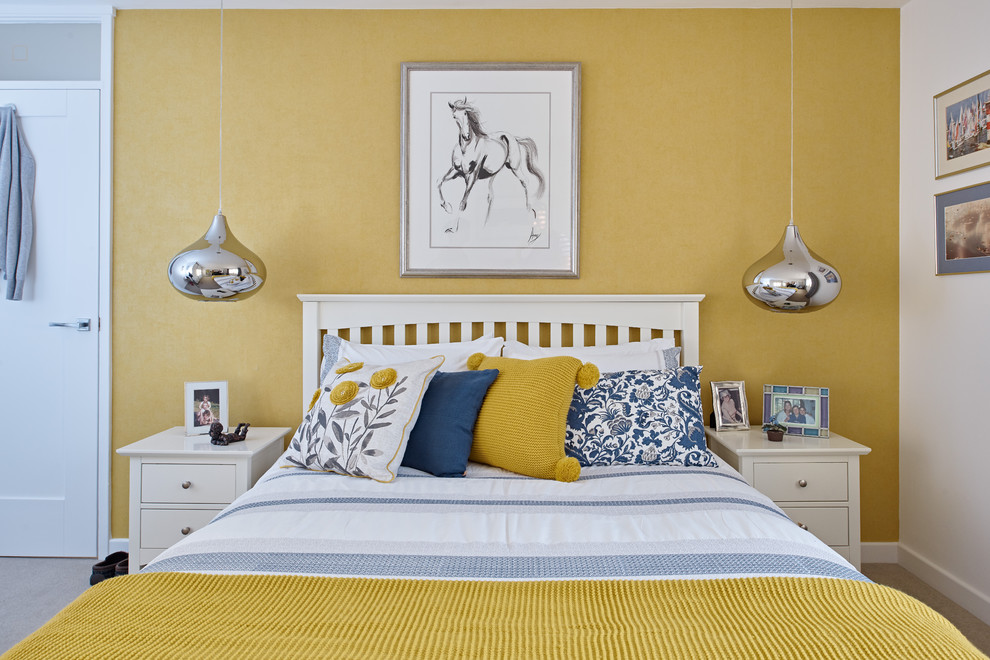Design ideas for a mid-sized transitional master bedroom in Berkshire with yellow walls, carpet and beige floor.
