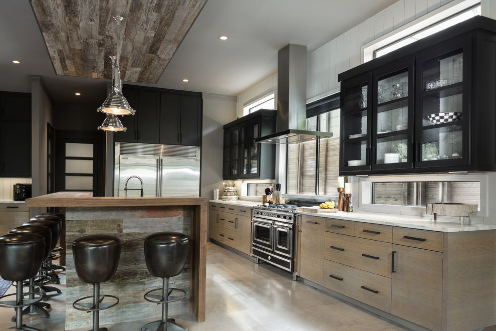 Design ideas for a large industrial l-shaped open plan kitchen in Dallas with an undermount sink, flat-panel cabinets, light wood cabinets, marble benchtops, white splashback, timber splashback, stainless steel appliances, concrete floors and with island.