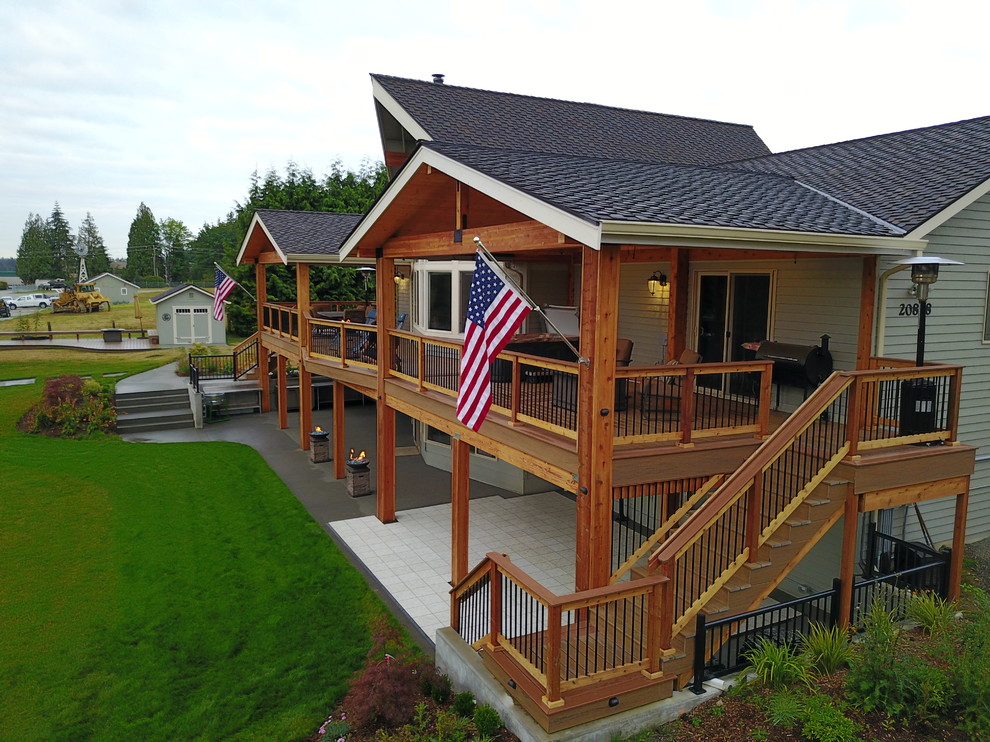 Inspiration for a large rustic backyard outdoor kitchen deck remodel in Seattle with a roof extension