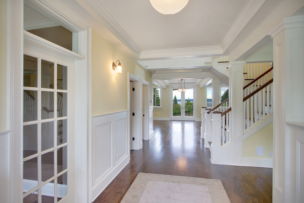 Traditional hallway in Seattle with yellow walls and dark hardwood floors.