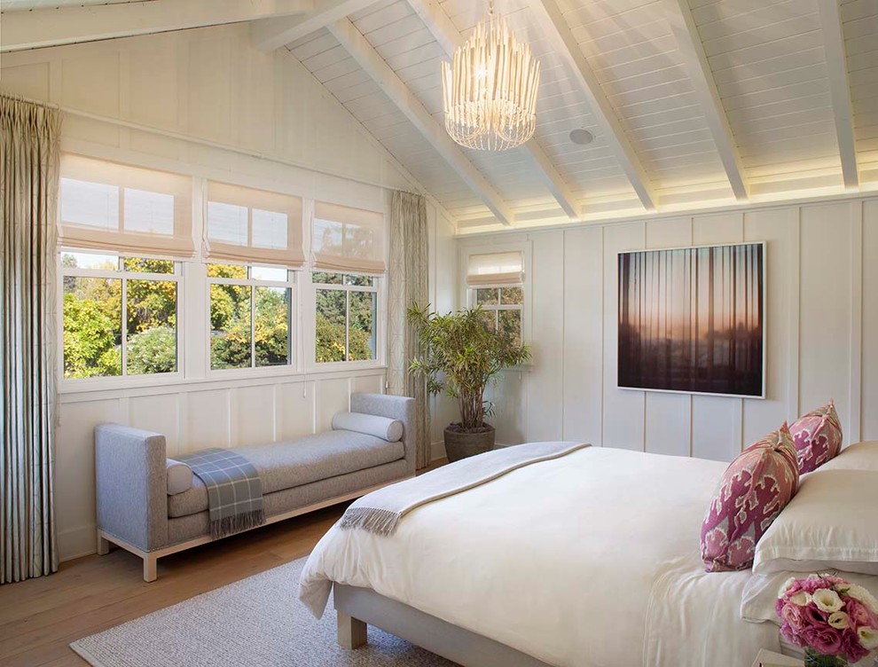 This is an example of a country bedroom in San Francisco with white walls, light hardwood floors and no fireplace.