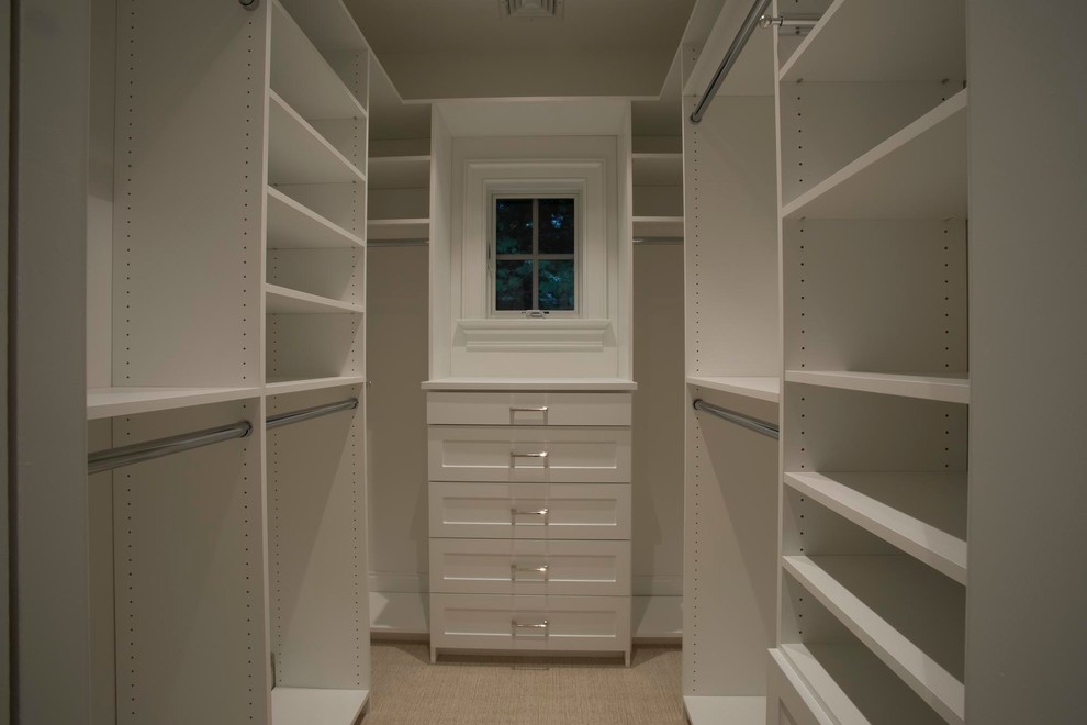 Small transitional gender-neutral walk-in wardrobe in New York with open cabinets, white cabinets, beige floor and carpet.