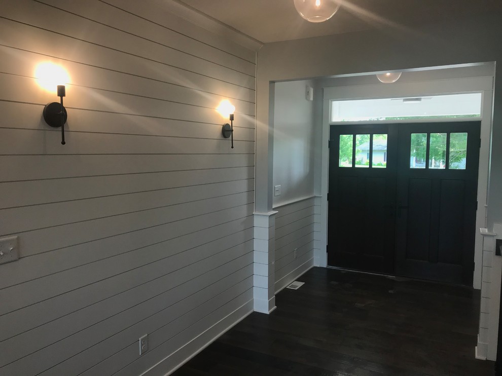 Mid-sized transitional dark wood floor and brown floor front door photo with white walls and a dark wood front door
