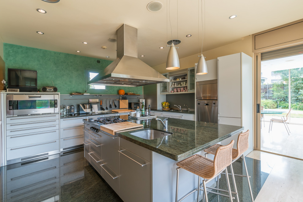 Contemporary l-shaped kitchen in Madrid with an undermount sink, flat-panel cabinets, grey cabinets, stainless steel appliances, with island, green floor and green benchtop.