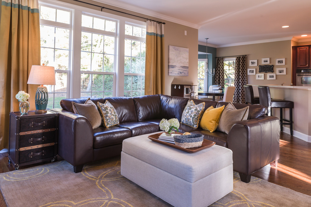 Photo of a transitional open concept family room in Charlotte with beige walls and dark hardwood floors.