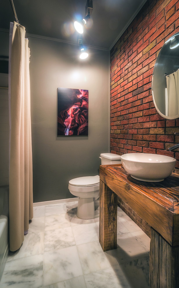 This is an example of a mid-sized industrial bathroom in Other with open cabinets, beige tile, marble floors, a vessel sink, wood benchtops and grey floor.