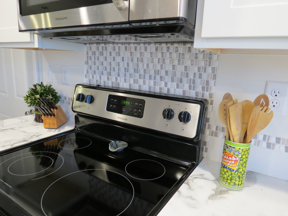 Inspiration for a mid-sized transitional kitchen remodel with shaker cabinets, white cabinets, multicolored backsplash, porcelain backsplash, stainless steel appliances and marble countertops