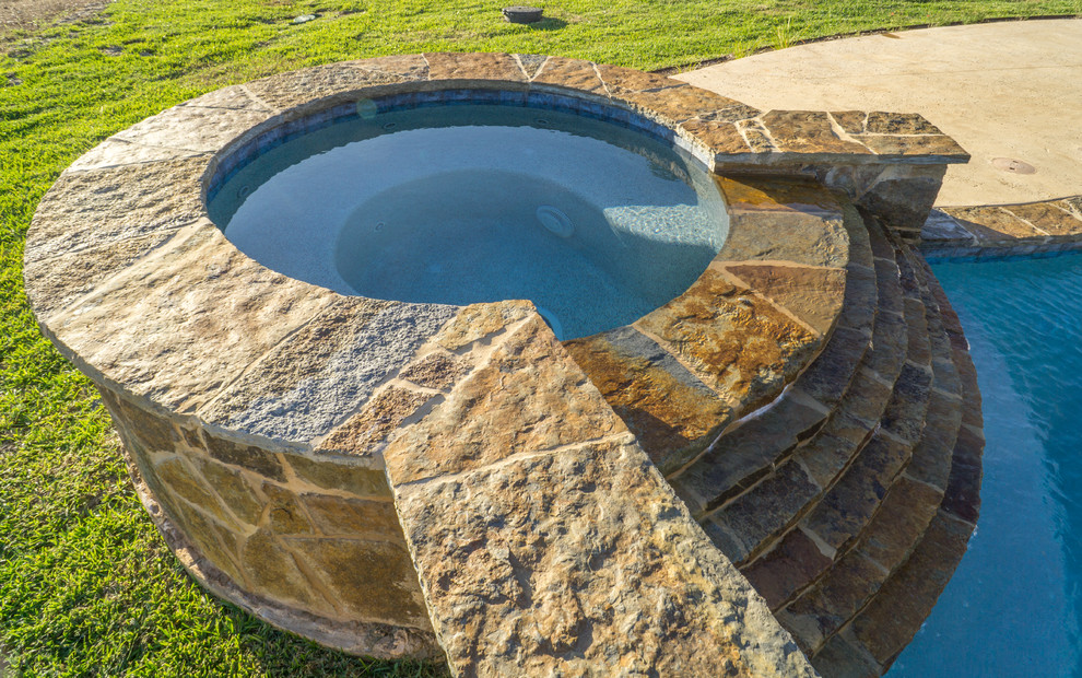 Water slide - large rustic backyard stone and custom-shaped water slide idea in Austin