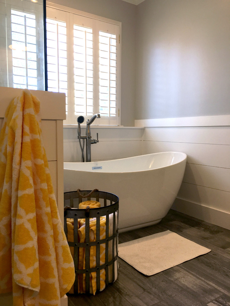 Large transitional master bathroom in Atlanta with furniture-like cabinets, grey cabinets, a freestanding tub, a corner shower, a two-piece toilet, white tile, ceramic tile, grey walls, porcelain floors, an undermount sink, marble benchtops, grey floor and a hinged shower door.