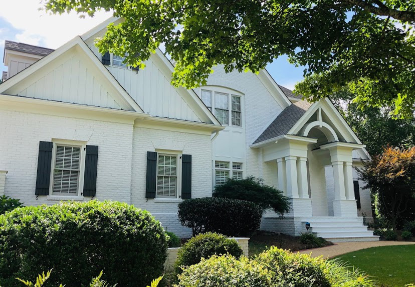 This is an example of a large transitional three-storey brick white house exterior in Atlanta with a gambrel roof and a shingle roof.