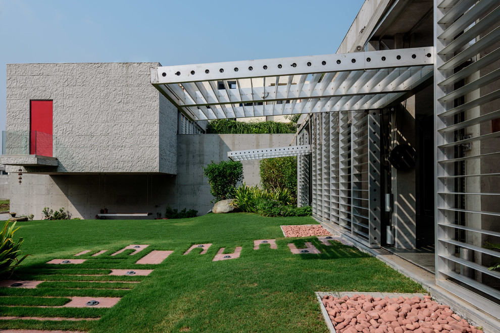 This is an example of a modern Two-story Concrete Grey exterior With a Flat Roof.