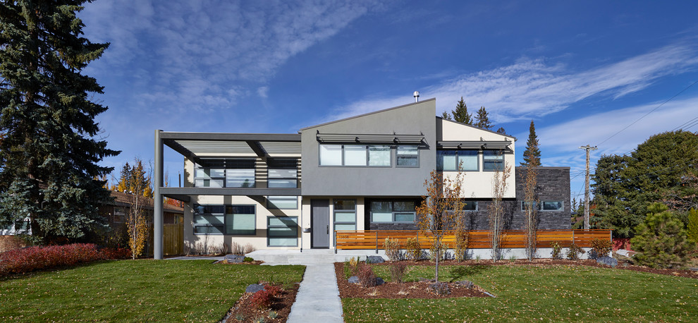 Inspiration for a contemporary two-storey exterior in Edmonton with mixed siding.