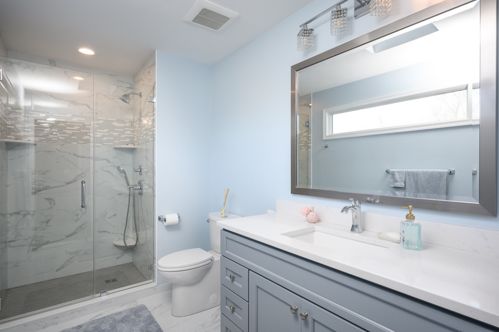 Mid-sized transitional kids' white tile and ceramic tile ceramic tile, white floor and single-sink alcove shower photo in DC Metro with recessed-panel cabinets, gray cabinets, blue walls, an undermount sink, quartz countertops, a hinged shower door, white countertops and a built-in vanity