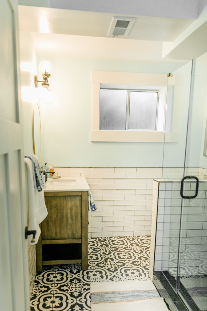 This is an example of a medium sized eclectic shower room bathroom in Seattle with an alcove shower, a one-piece toilet, white tiles, ceramic tiles, white walls, mosaic tile flooring, a submerged sink, quartz worktops, multi-coloured floors, a hinged door, white worktops, an enclosed toilet, a single sink, a freestanding vanity unit and wallpapered walls.