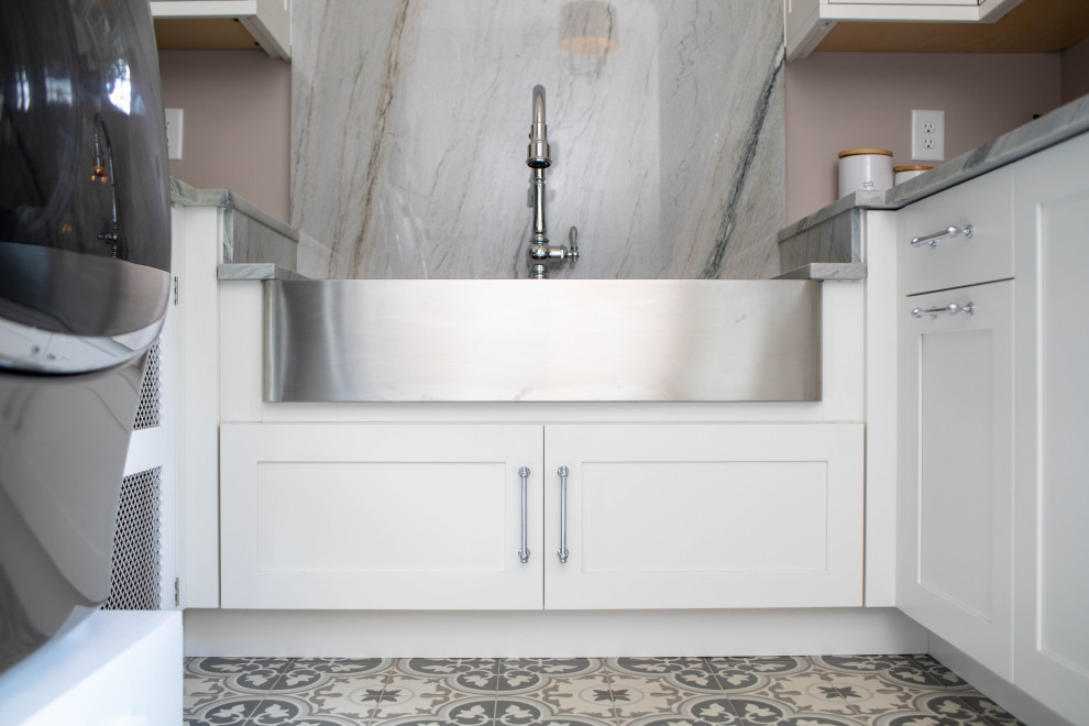 This is an example of a transitional u-shaped laundry room in Other with a farmhouse sink, shaker cabinets, white cabinets, marble benchtops and grey benchtop.