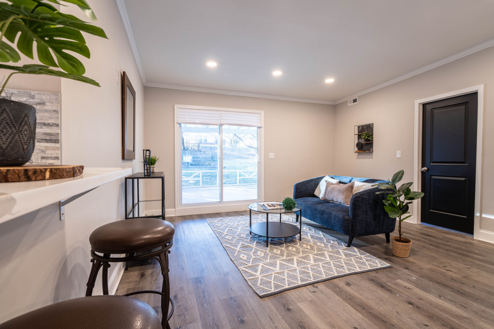 Esempio di un soggiorno tradizionale di medie dimensioni con pareti beige, pavimento in laminato, angolo bar e pavimento grigio