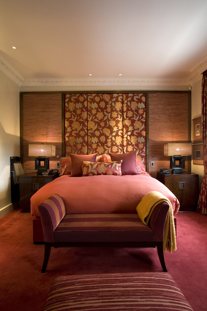 Inspiration for a mid-sized transitional bedroom in London with beige walls, carpet and red floor.