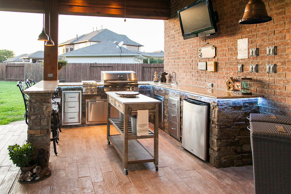 Inspiration for a mid-sized country backyard patio in Houston with an outdoor kitchen, stamped concrete and a roof extension.