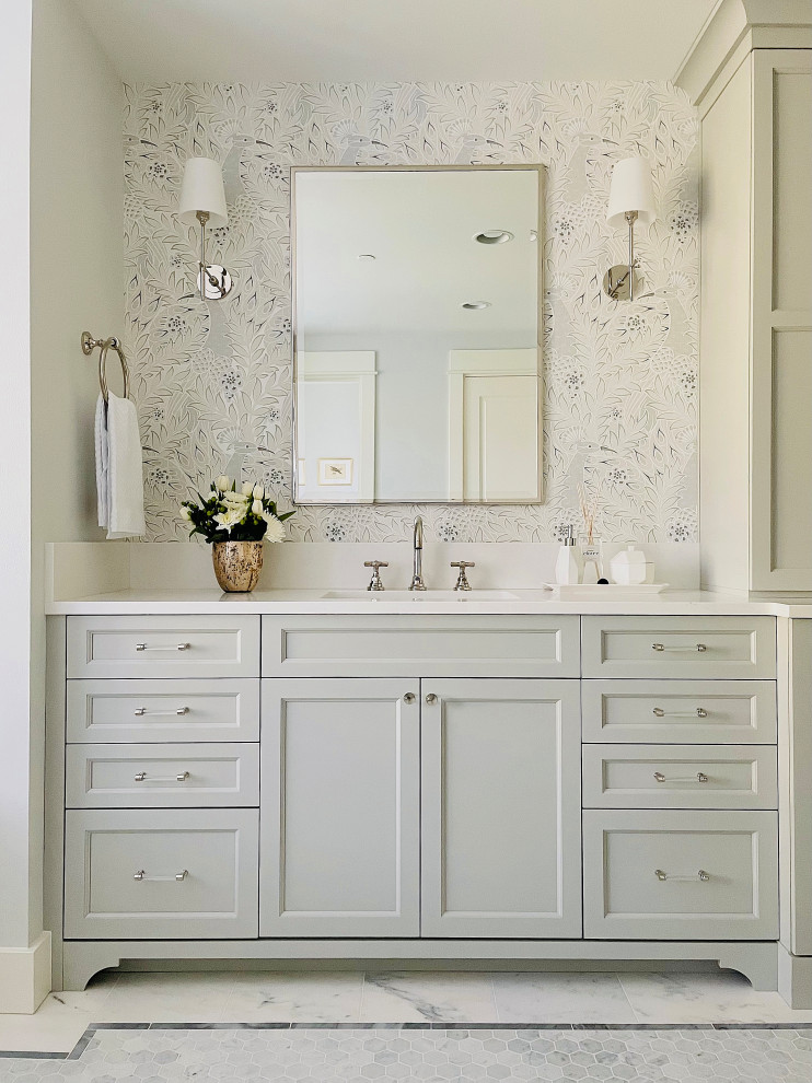 Inspiration for a large transitional master bathroom with recessed-panel cabinets, grey cabinets, a drop-in tub, a double shower, a two-piece toilet, white tile, marble, grey walls, marble floors, an undermount sink, engineered quartz benchtops, white floor, a hinged shower door, white benchtops, a shower seat, a double vanity, a built-in vanity and wallpaper.