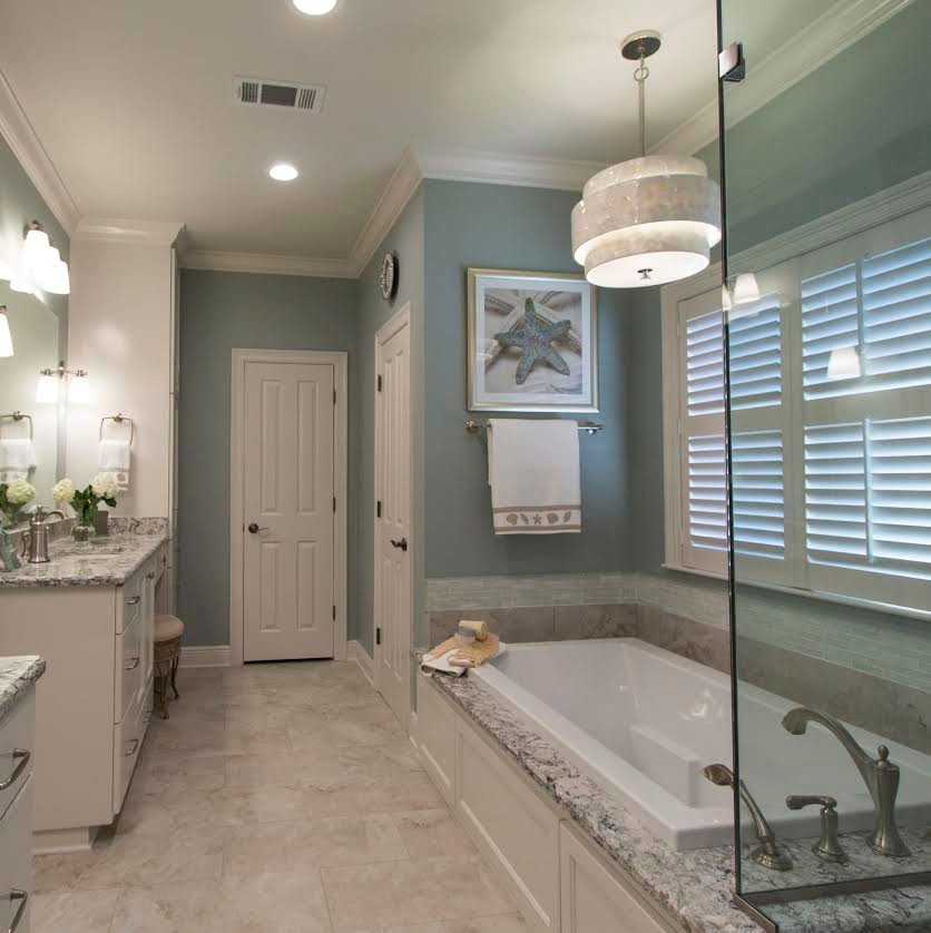 Inspiration for a mid-sized beach style master bathroom in New Orleans with an undermount sink, recessed-panel cabinets, white cabinets, engineered quartz benchtops, a drop-in tub, a shower/bathtub combo, beige tile, porcelain tile, porcelain floors and green walls.