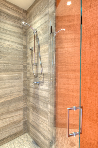 Example of a minimalist multicolored tile and stone tile corner shower design