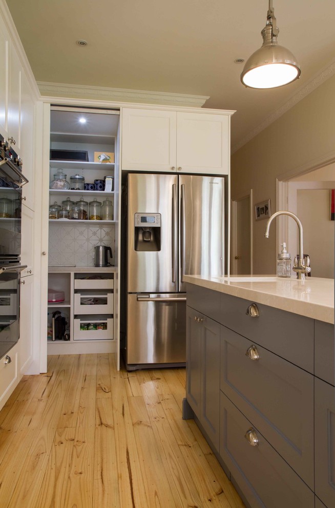 Design ideas for a large traditional u-shaped open plan kitchen in Melbourne with shaker cabinets, light hardwood floors and with island.