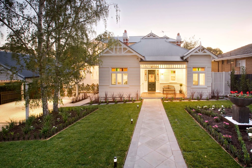 This is an example of a mid-sized traditional white exterior in Melbourne with wood siding.