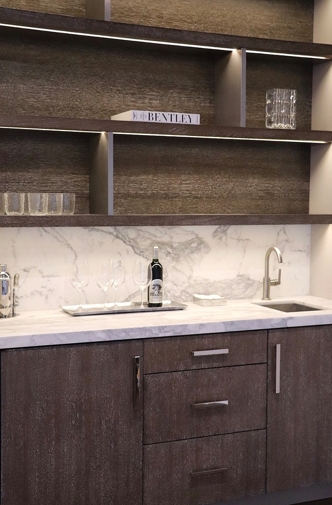 Inspiration for a mid-sized contemporary single-wall wet bar in New York with an undermount sink, flat-panel cabinets, medium wood cabinets, marble benchtops, white splashback, marble splashback, dark hardwood floors, brown floor and white benchtop.