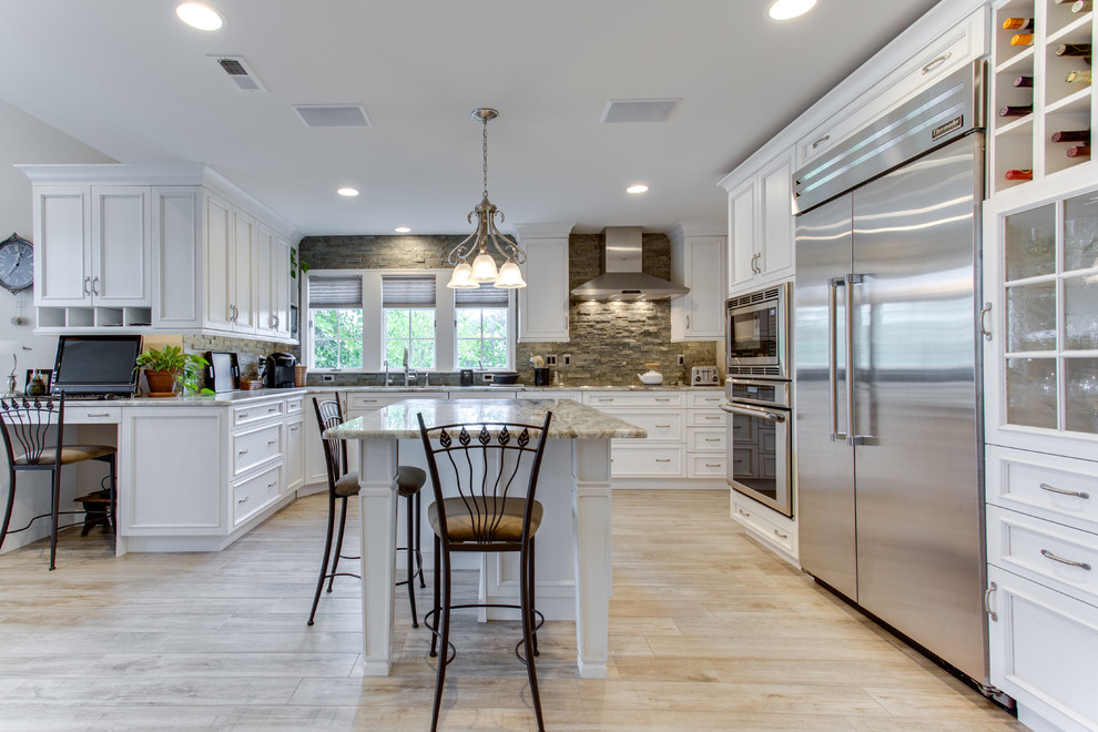 Inspiration for a large traditional u-shaped kitchen in DC Metro with an undermount sink, recessed-panel cabinets, granite benchtops, stone tile splashback, stainless steel appliances and multiple islands.