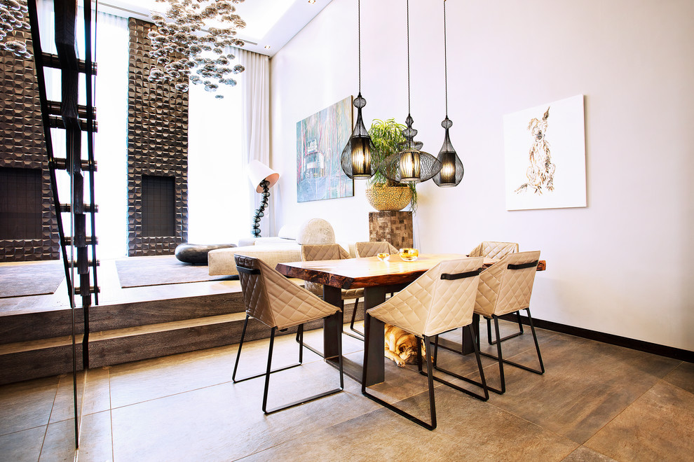 This is an example of a mid-sized contemporary dining room in London with beige walls, a standard fireplace and grey floor.