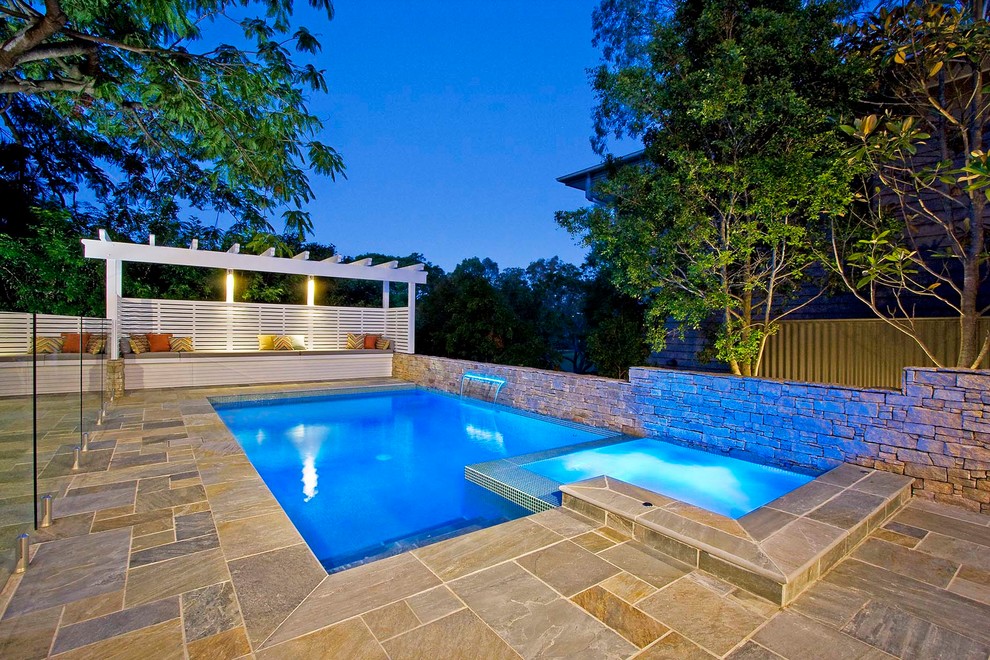 Mid-sized contemporary backyard rectangular pool in Brisbane with a hot tub and natural stone pavers.
