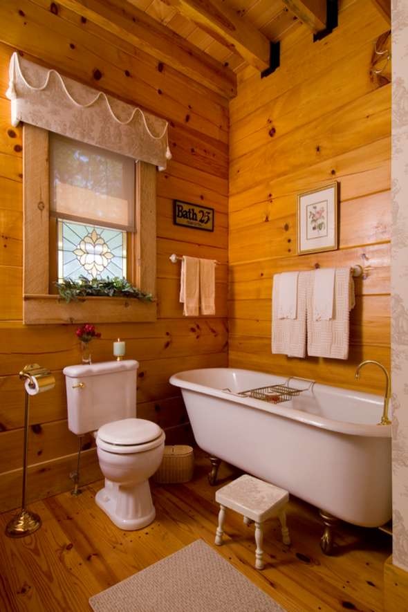 Mid-sized country 3/4 bathroom in Nashville with a claw-foot tub, a two-piece toilet, brown walls and medium hardwood floors.