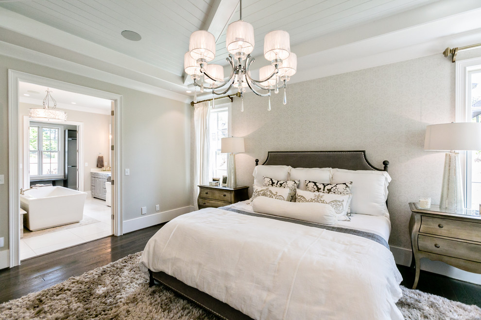 This is an example of a large transitional master bedroom in Birmingham with grey walls and dark hardwood floors.