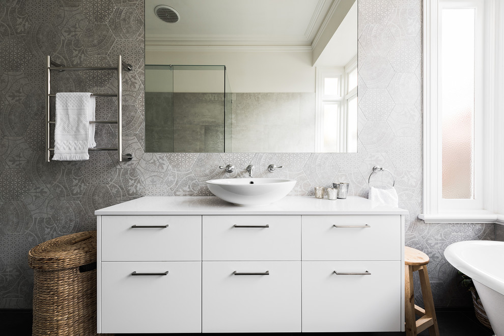 Design ideas for a mid-sized contemporary master bathroom in Melbourne with flat-panel cabinets, white cabinets, a claw-foot tub, a one-piece toilet, gray tile, ceramic tile, grey walls, a vessel sink and engineered quartz benchtops.