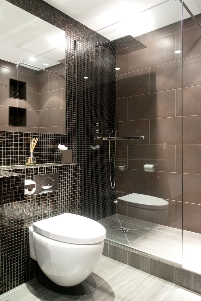 This is an example of a mid-sized eclectic bathroom in London with tile benchtops, an open shower, a wall-mount toilet, brown tile, mosaic tile, brown walls and ceramic floors.
