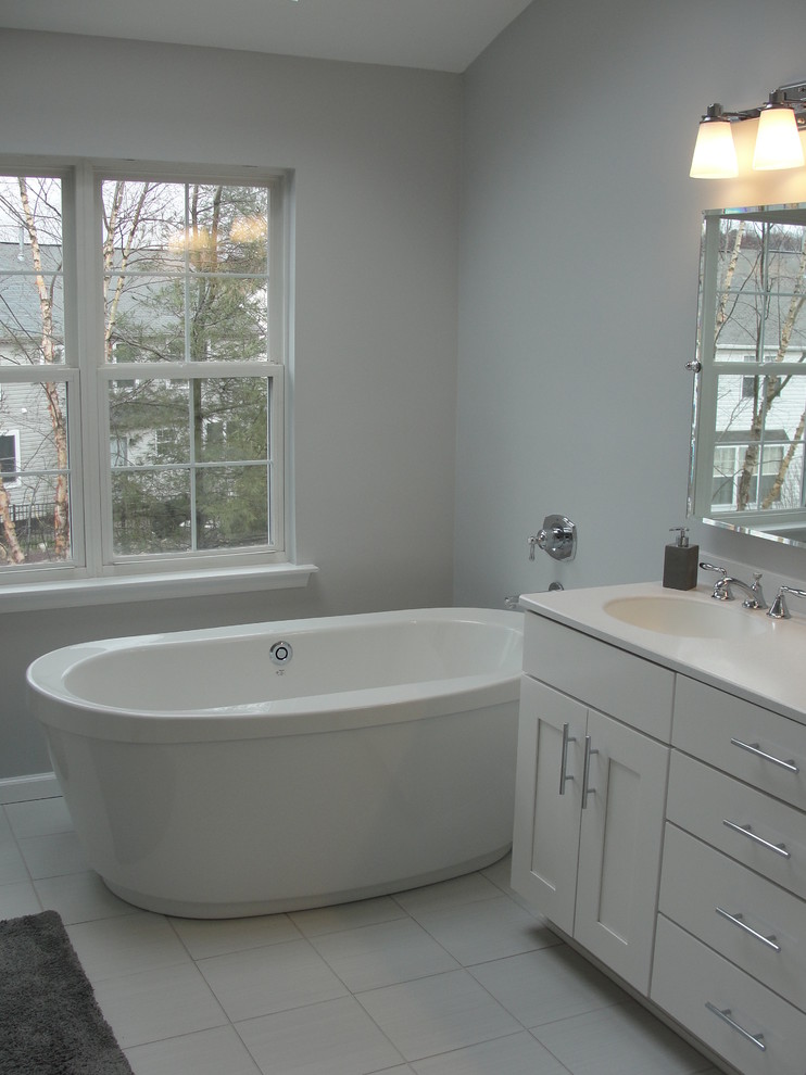 Design ideas for a mid-sized transitional master bathroom in Philadelphia with recessed-panel cabinets, grey cabinets, a freestanding tub, grey walls and an integrated sink.