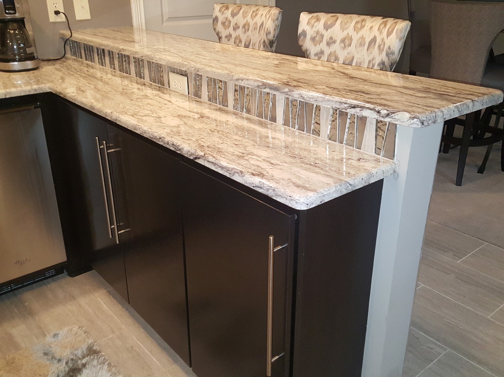 Inspiration for a mid-sized modern u-shaped wet bar in Indianapolis with an undermount sink, flat-panel cabinets, black cabinets, limestone benchtops, grey splashback, glass tile splashback and ceramic floors.