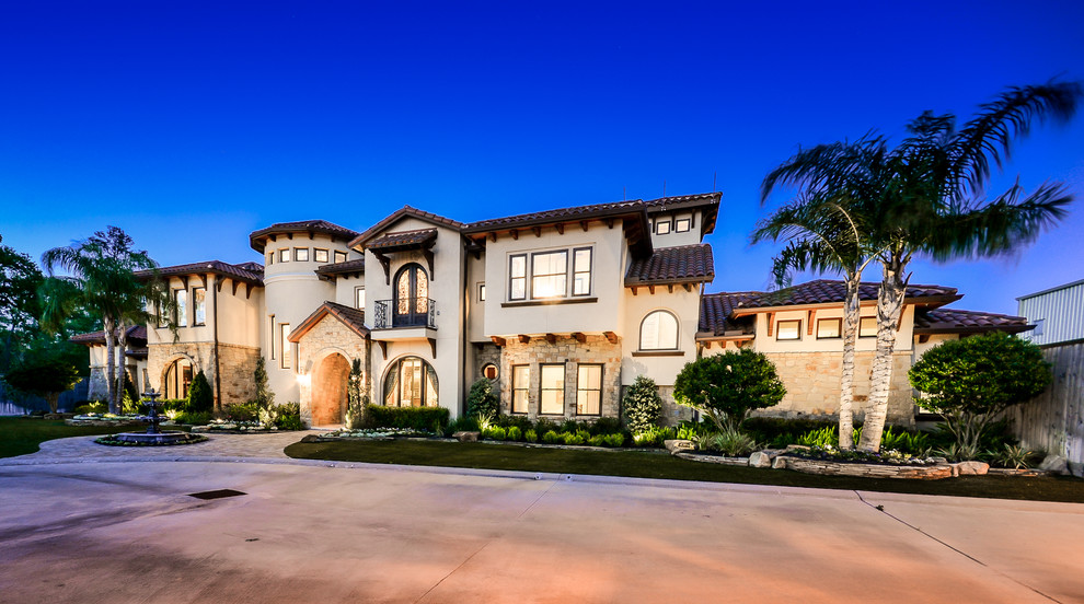 Photo of a large mediterranean two-storey stucco beige exterior in Houston.