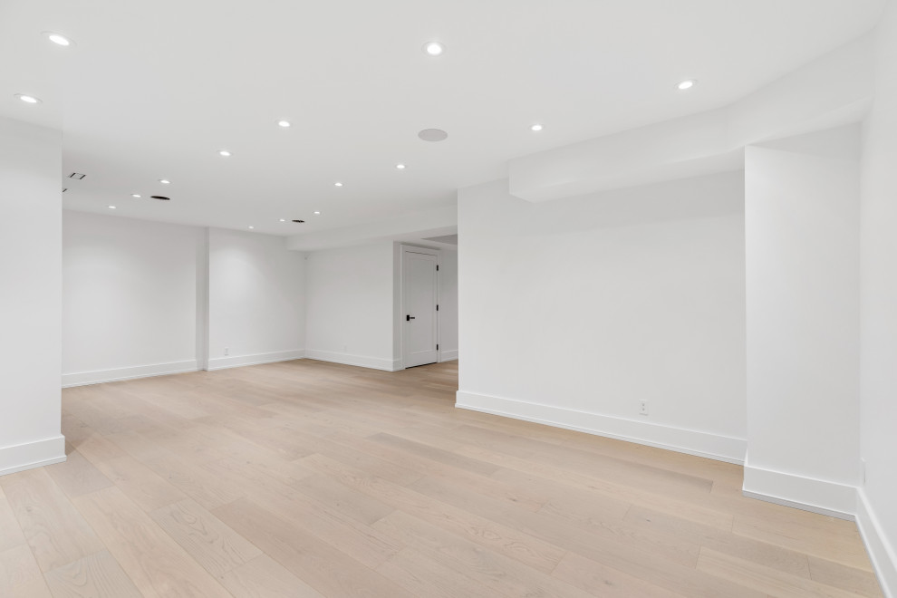 Basement game room - huge modern walk-out light wood floor and beige floor basement game room idea in Toronto with white walls