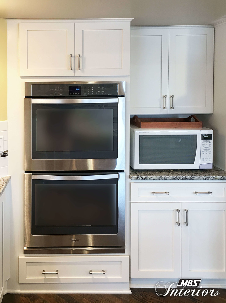 Eat-in kitchen - huge transitional u-shaped medium tone wood floor and brown floor eat-in kitchen idea with an undermount sink, shaker cabinets, white cabinets, granite countertops, white backsplash, subway tile backsplash, stainless steel appliances and an island